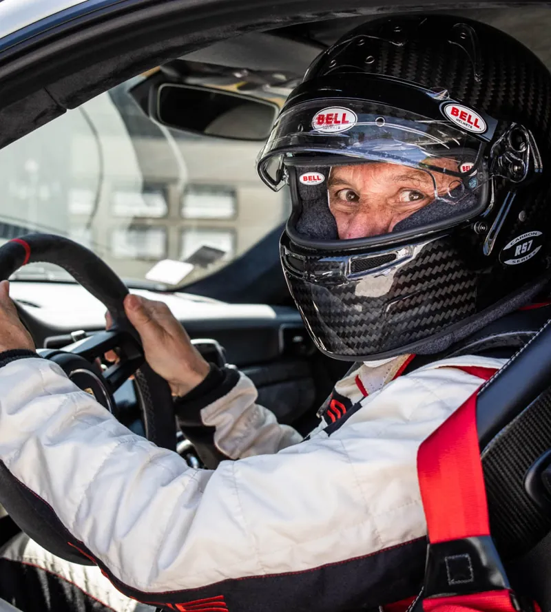 Pilota con casco al volante