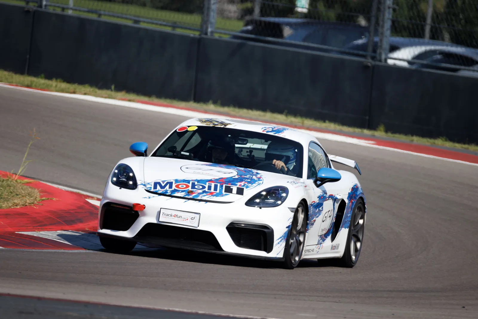 Porsche 718 GT4 bianca Mobil 1 in curva